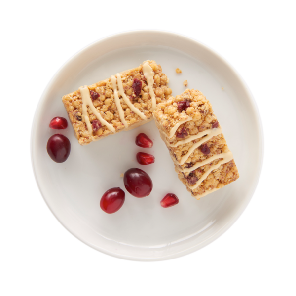 Bar on white plate with pieces of pomegranate and cranberries.